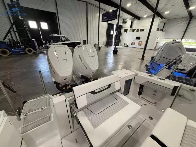 Slide: The Image of 2025 Blackfin 332 CC boat with twin outboard engines in a showroom. - 13