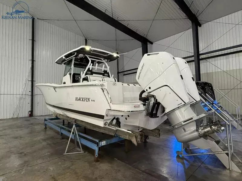 Slide: The Image of 2025 Blackfin 332 CC boat in a warehouse, displayed on a stand. - 4