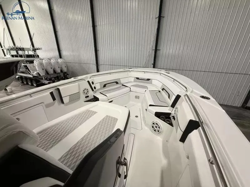 Slide: The Image of 2025 Blackfin 332 CC boat interior with sleek seating and modern design in a showroom. - 8