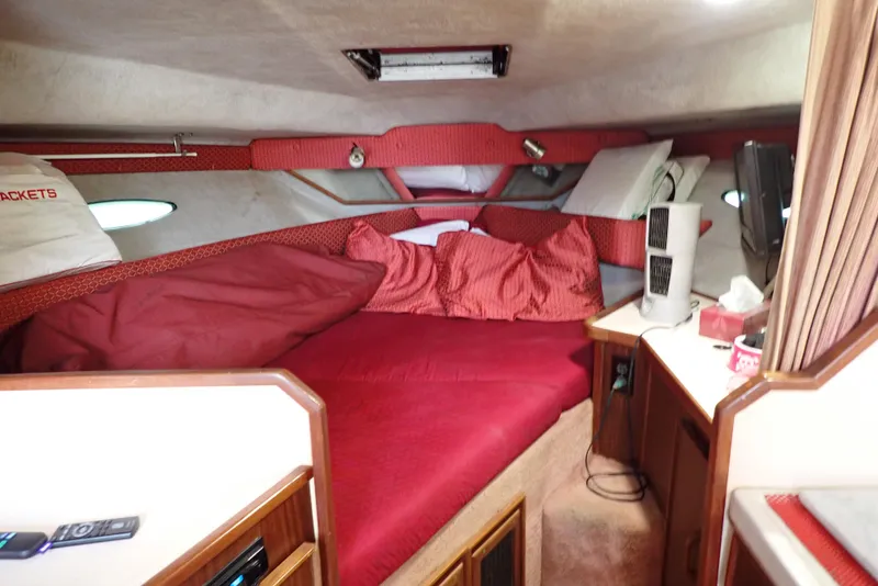 Slide: The Image of Interior cabin of 1987 Sea Ray 300 Weekender with red bedding and wood accents. - 12