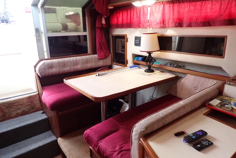 Slide: The Image of Interior of 1987 Sea Ray 300 Weekender with red seating, table, and lamp. - 13