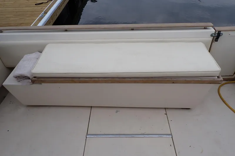 Slide: The Image of 1987 Sea Ray 300 Weekender boat bench seat by the water. - 22