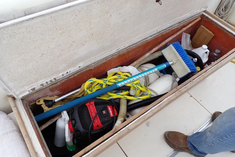 Slide: The Image of Storage compartment on a 1987 Sea Ray 300 Weekender with cleaning supplies and equipment. - 23