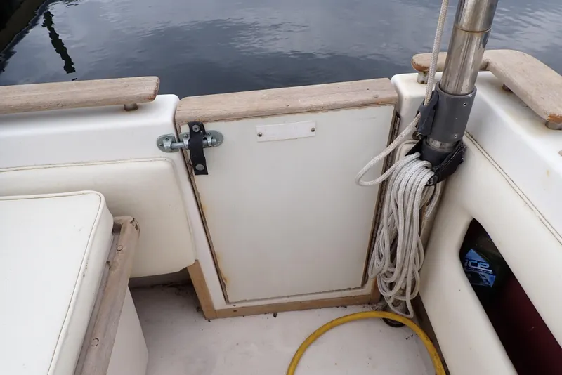 Slide: The Image of 1987 Sea Ray 300 Weekender boat deck with storage compartment and coiled rope. - 27