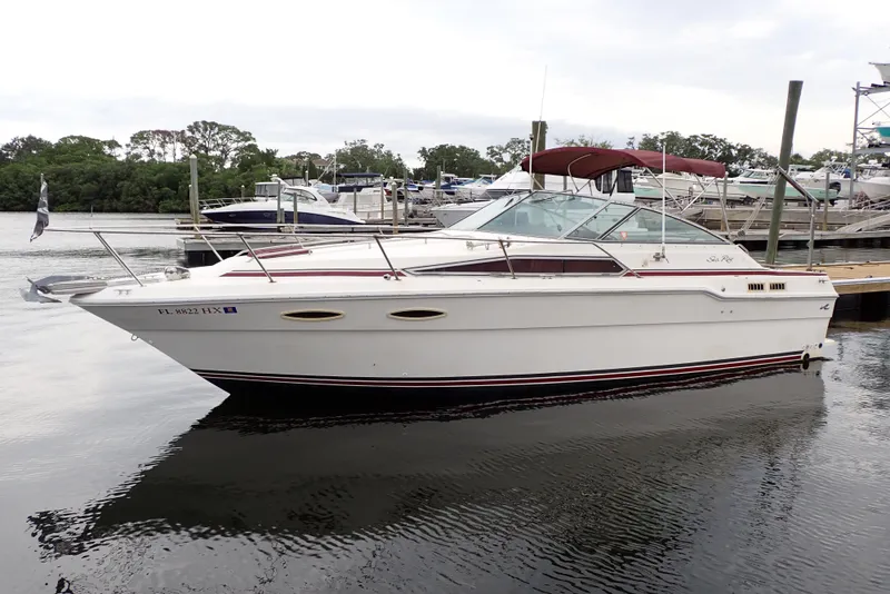 Slide: The Image of 1987 Sea Ray 300 Weekender boat docked at marina, featuring classic design and white exterior. - 3