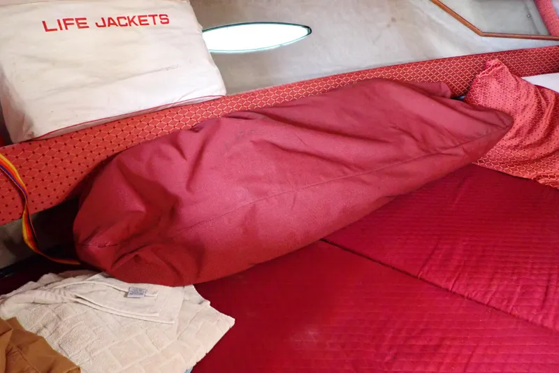 Slide: The Image of Interior of 1987 Sea Ray 300 Weekender with red bedding and life jackets. - 31