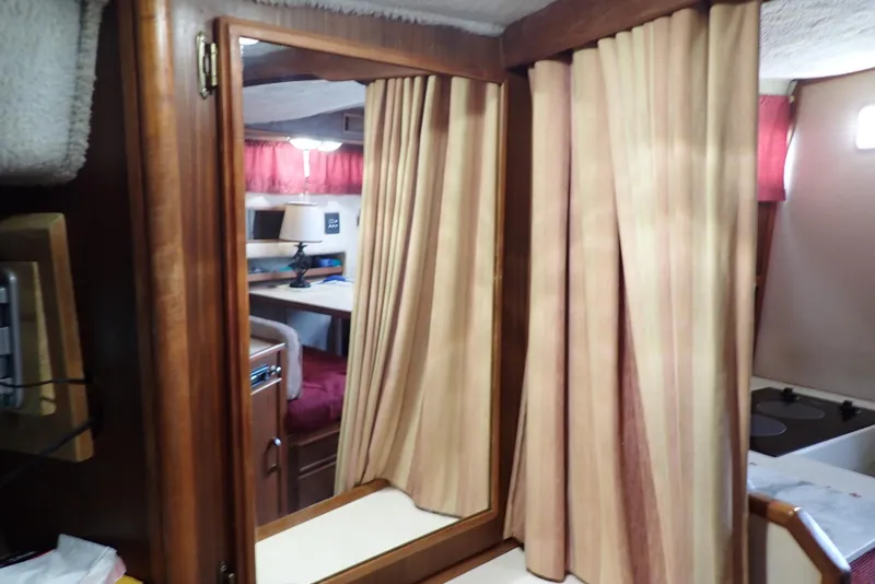 Slide: The Image of Interior of 1987 Sea Ray 300 Weekender with wood paneling and striped curtains. - 38