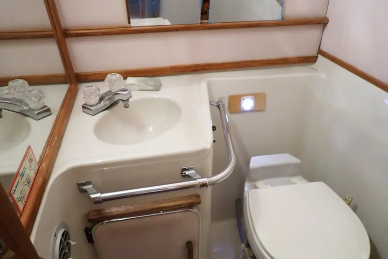 Slide: The Image of 1987 Sea Ray 300 Weekender bathroom with sink, mirror, and toilet. - 42