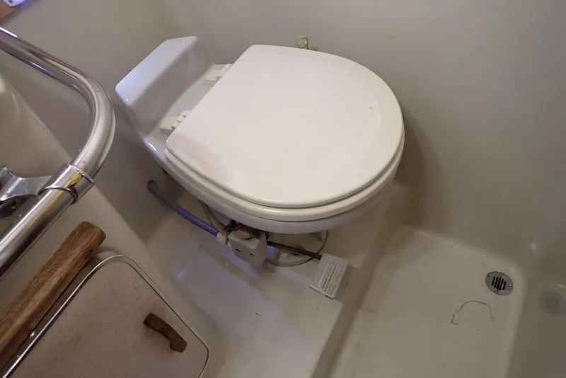 Slide: The Image of 1987 Sea Ray 300 Weekender boat bathroom with toilet and shower area. - 43
