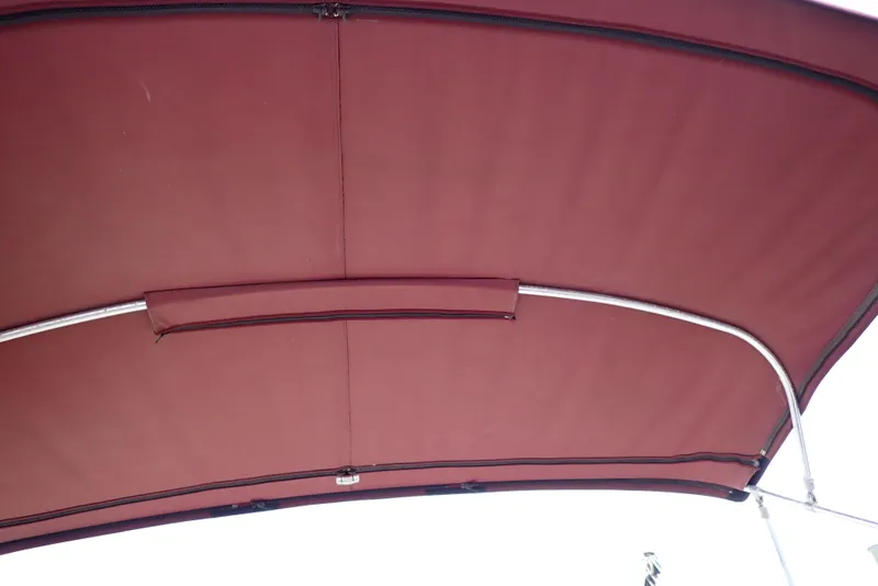 Slide: The Image of Maroon canopy of 1987 Sea Ray 300 Weekender boat, featuring metal support frame. - 46