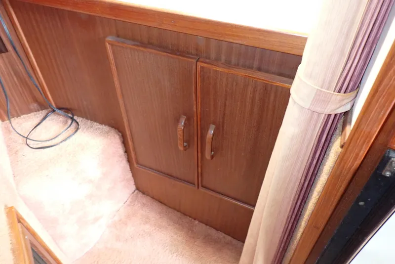 Slide: The Image of 1987 Sea Ray 300 Weekender interior with wooden cabinets and carpeted flooring. - 47