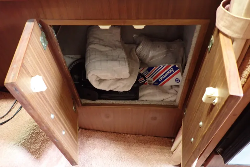 Slide: The Image of Storage compartment in 1987 Sea Ray 300 Weekender boat with blankets and supplies. - 48