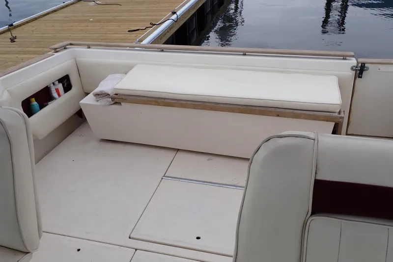 Slide: The Image of 1987 Sea Ray 300 Weekender boat interior with white seating and dock view. - 5