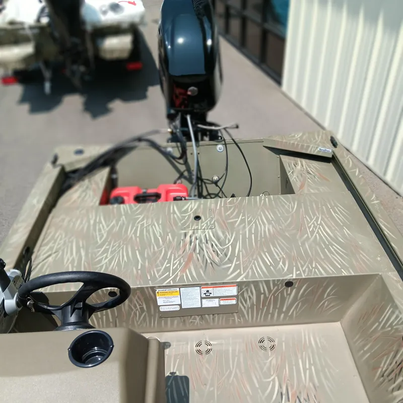 Slide: The Image of 2025 Tracker Grizzly 1648 SC boat interior with camouflage design and steering wheel. - 11