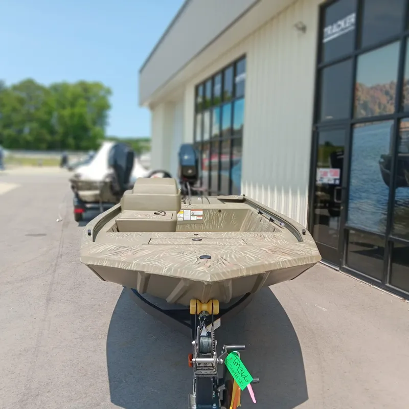 Slide: The Image of 2025 Tracker Grizzly 1648 SC boat displayed outside a showroom. - 4