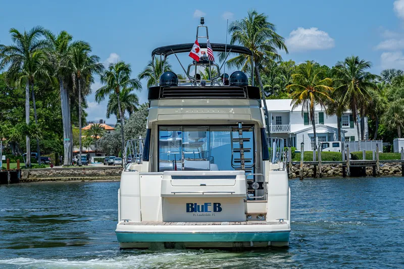 Slide: The Image of 2015 Beneteau MONTE CARLO yacht cruising near palm-lined waterfront homes. - 11