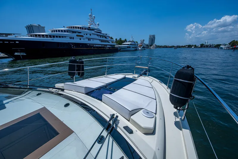 Slide: The Image of 2015 Beneteau MONTE CARLO yacht with sunbathing deck, docked near luxury vessels. - 14