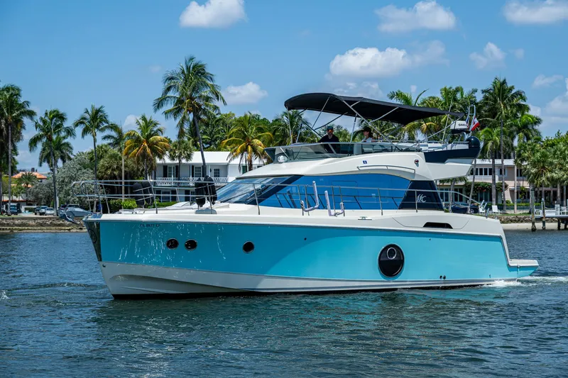 Slide: The Image of 2015 Beneteau Monte Carlo yacht cruising on a sunny day with palm trees in the background. - 2