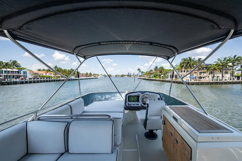 Slide: The Image of 2015 Beneteau MONTE CARLO yacht interior with helm, white seating, and waterfront view. - 31