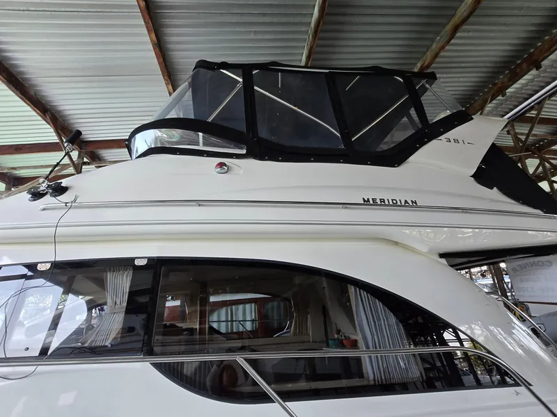 Slide: The Image of 2004 Meridian 381 Sedan yacht under a metal roof, showcasing sleek design and windows. - 10