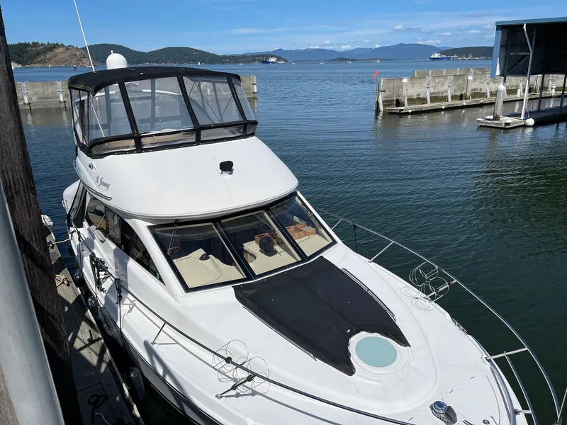 Slide: The Image of 2004 Meridian 381 Sedan docked at a marina with scenic water and mountain views. - 2