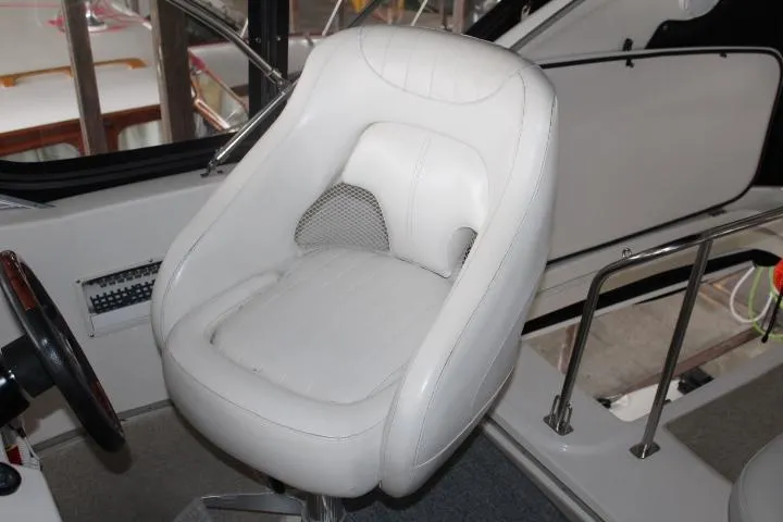 Slide: The Image of Captain's chair in 2004 Meridian 381 Sedan boat cockpit, featuring white upholstery and modern design. - 21