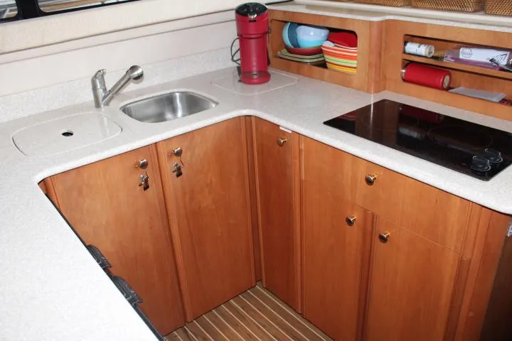 Slide: The Image of Compact kitchen in 2004 Meridian 381 Sedan with sink, stove, and wooden cabinets. - 41