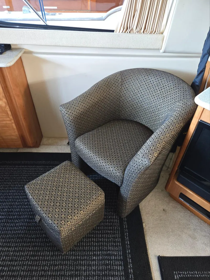 Slide: The Image of Comfortable patterned chair and ottoman inside a 2004 Meridian 381 Sedan yacht. - 49