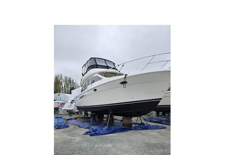 Slide: The Image of 2004 Meridian 381 Sedan yacht on dry dock, covered with tarps, overcast sky. - 89