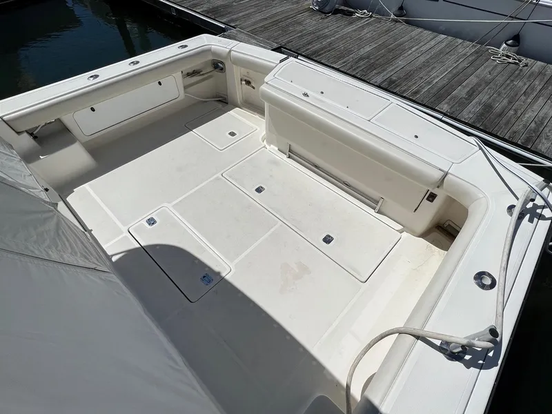 Slide: The Image of Spacious deck of 1996 Tiara Yachts 4300 Open, featuring clean white seating and storage. - 11