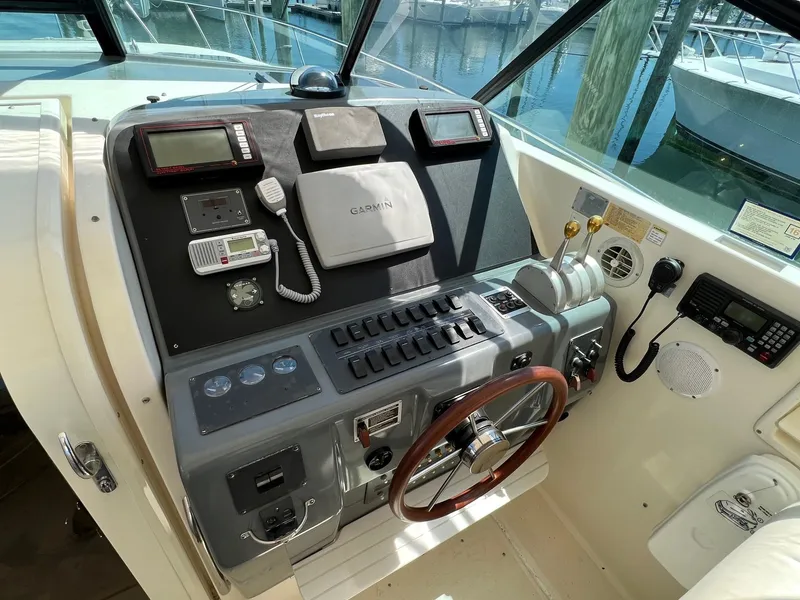 Slide: The Image of 1996 Tiara Yachts 4300 Open helm with Garmin navigation, steering wheel, and control panel. - 13