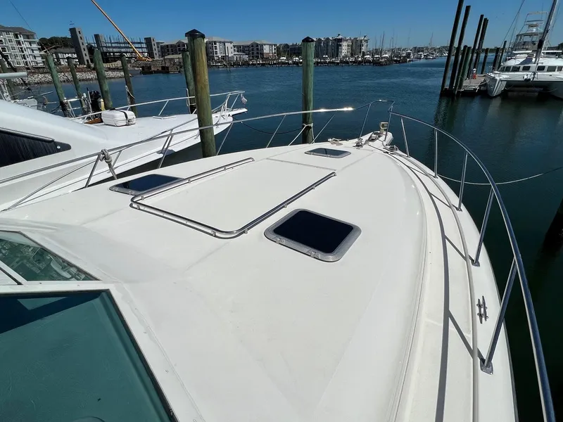 Slide: The Image of 1996 Tiara Yachts 4300 Open docked at marina, showcasing sleek deck design. - 6