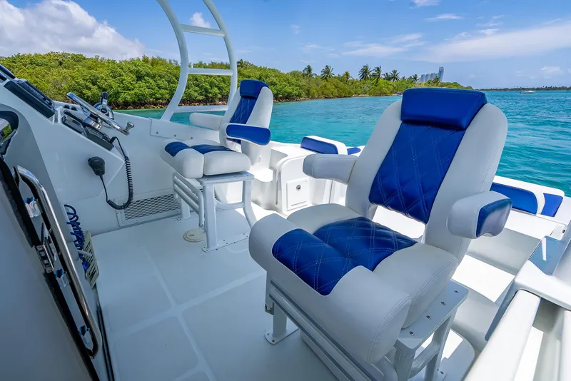 Slide: The Image of 2020 Nova 39 Sport boat interior with blue and white seating, ocean view, and lush greenery. - 36