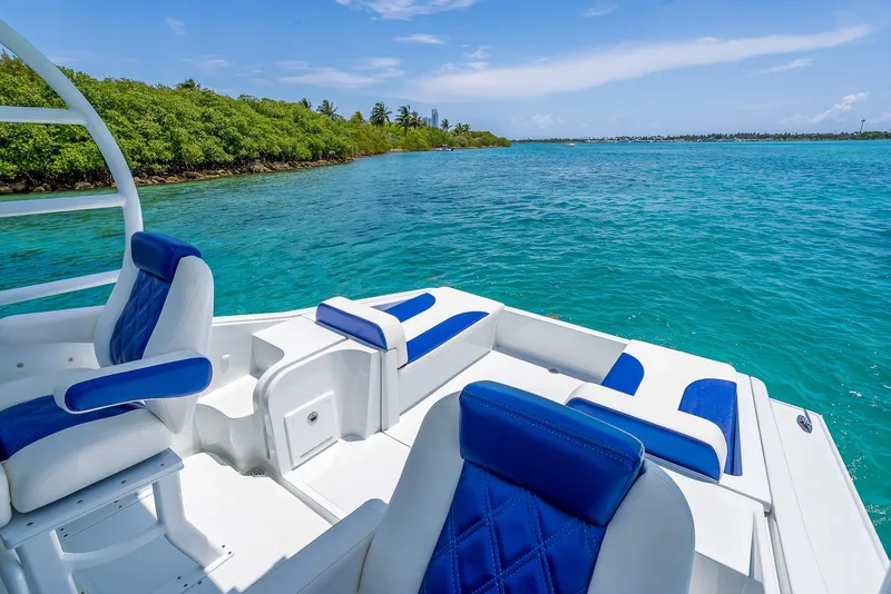 Slide: The Image of Nova 39 Sport 2020 boat with blue seating on clear turquoise water near lush shoreline. - 38