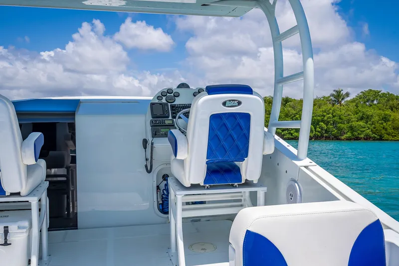 Slide: The Image of Nova 39 Sport 2020 boat interior with blue and white seating, steering console, and ocean view. - 43