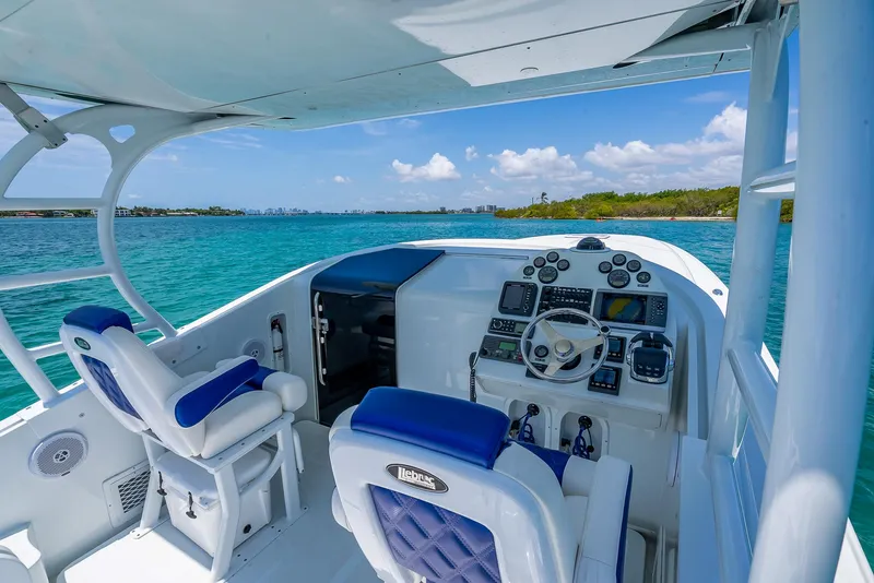 Slide: The Image of 2020 Nova 39 Sport boat cockpit with blue seats, steering wheel, and ocean view. - 45