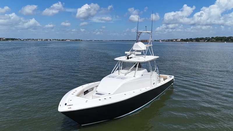 Slide: The Image of 2015 SeaVee 43 Fish-Around boat on calm water, featuring a sleek design and spacious deck. - 10