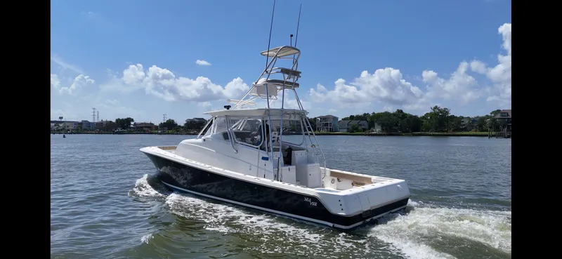 Slide: The Image of 2015 SeaVee 43 Fish-Around boat on calm water under blue sky. - 11