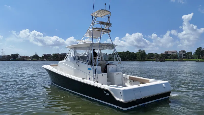 Slide: The Image of 2015 SeaVee 43 Fish-Around boat on calm water under a clear blue sky. - 26