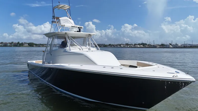Slide: The Image of 2015 SeaVee 43 Fish-Around boat on calm water under a clear blue sky. - 28