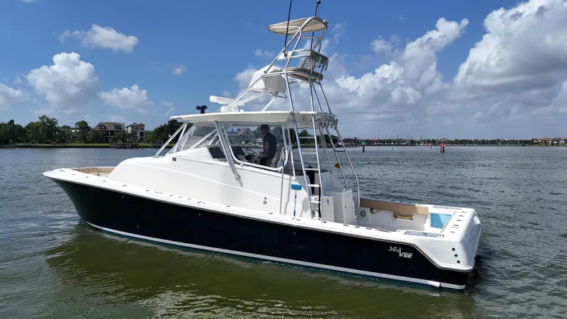 Slide: The Image of 2015 SeaVee 43 Fish-Around boat on calm water under a blue sky. - 30