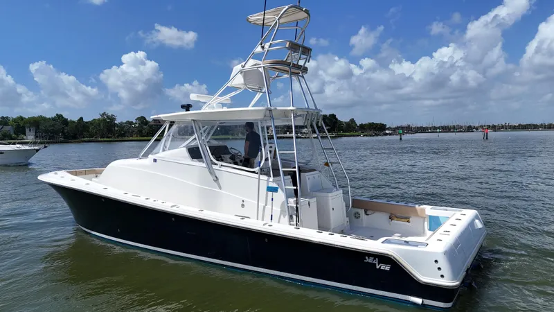 Slide: The Image of 2015 SeaVee 43 Fish-Around boat on calm water under a blue sky. - 32