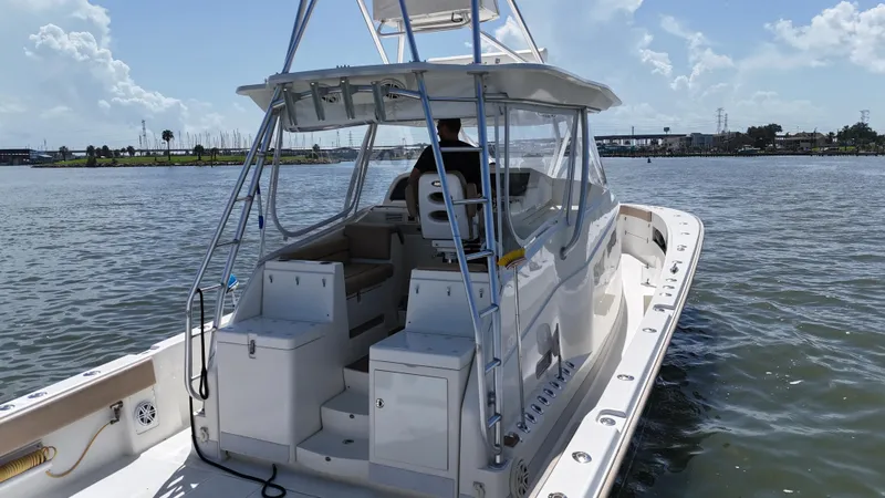 Slide: The Image of 2015 SeaVee 43 Fish-Around boat on calm water, featuring spacious deck and modern design. - 34