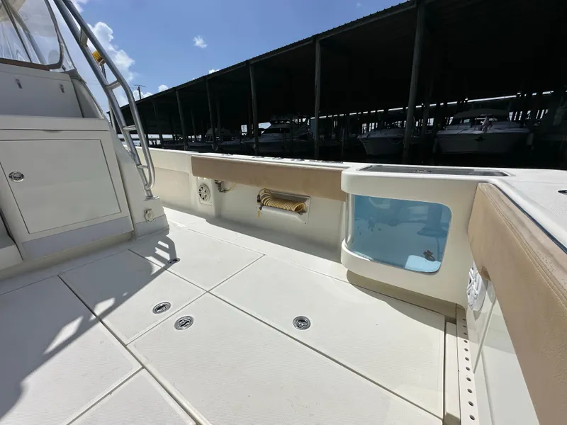 Slide: The Image of 2015 SeaVee 43 Fish-Around boat deck with storage and seating under sunny sky. - 43