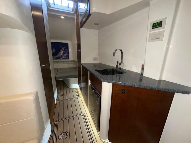 Slide: The Image of 2015 SeaVee 43 Fish-Around interior with modern kitchenette and wood accents. - 63