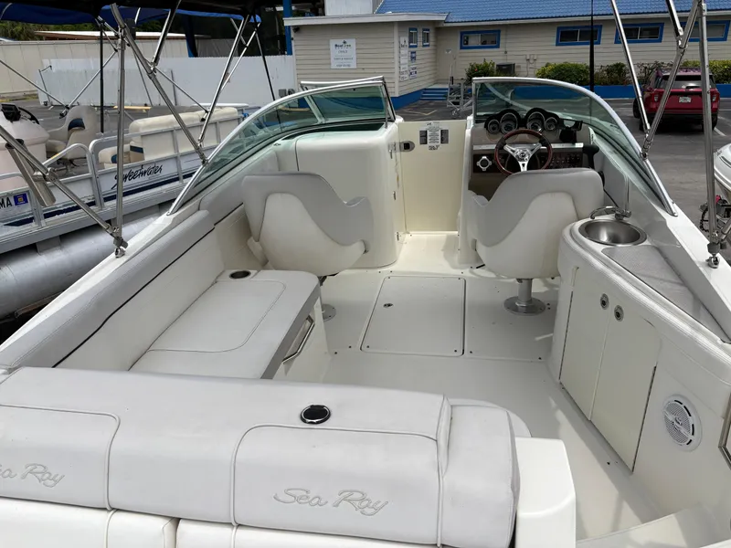 Slide: The Image of 2012 Sea Ray 260 Sundeck boat interior with seating and helm, docked at marina. - 12