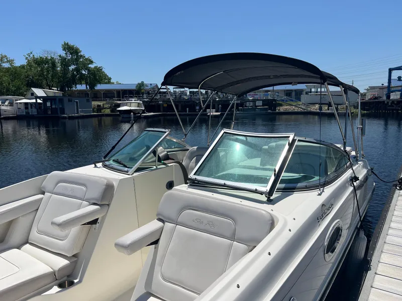 Slide: The Image of 2012 Sea Ray 260 Sundeck boat docked, featuring sleek design and comfortable seating. - 16