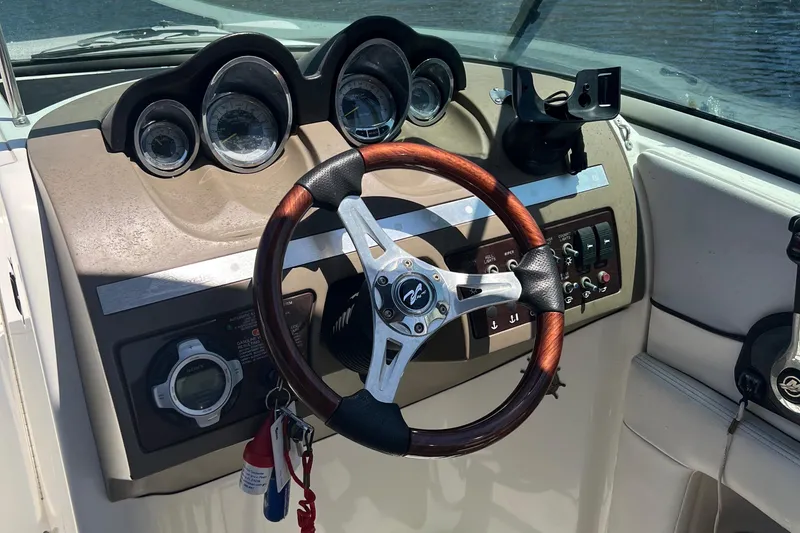Slide: The Image of Steering console of 2012 Sea Ray 260 Sundeck with gauges and wood-accented wheel. - 23
