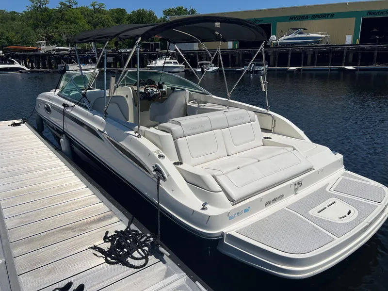 Slide: The Image of 2012 Sea Ray 260 Sundeck boat docked, featuring spacious seating and canopy. - 29