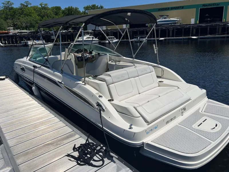 Slide: The Image of 2012 Sea Ray 260 Sundeck boat docked at marina, featuring spacious seating and canopy. - 3